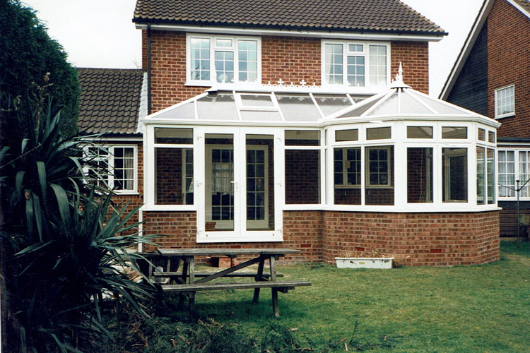 White PVCu Victorian P Shape Combination Dwarf wall Conservatory with 25mm Bronze polycarbonate roof sheets & French doors