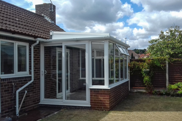 White PVCu Lean-To Conervatory with solar control glass roof sheets, Patio doors & Box gutter to house wall