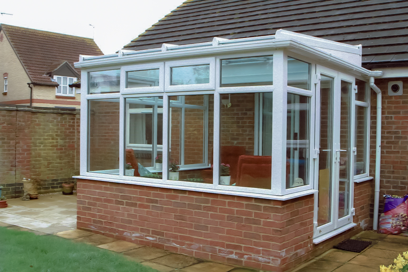 White PVCu Lean-To Conervatory with solar control glass roof sheets, French doors & Box gutter to house wall