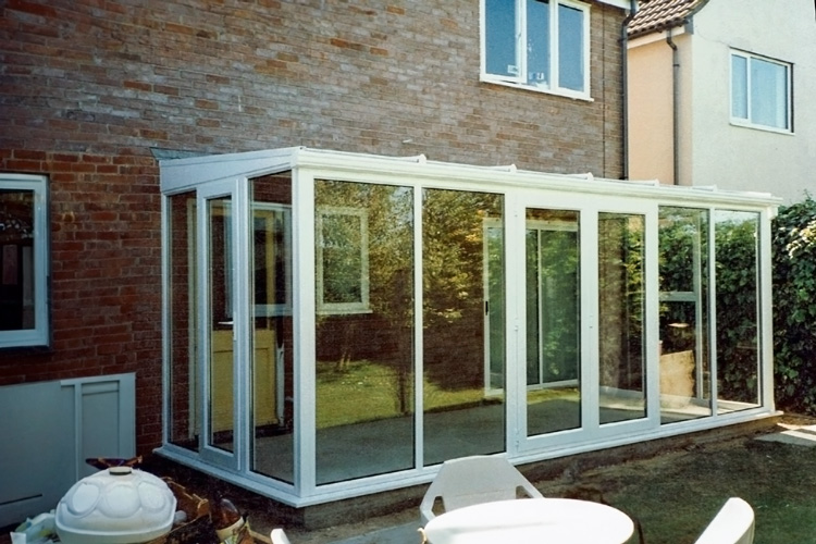 White PVCu glass to floor Lean-To Conservatory with Opal polycarbonate roof sheets, French & single doors